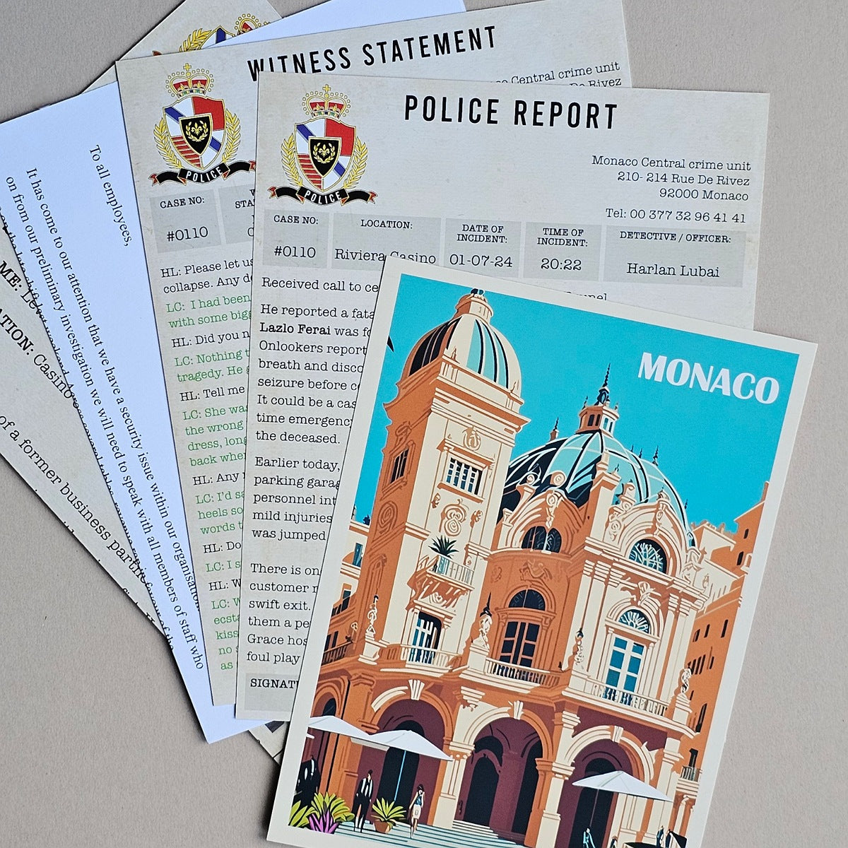 A stack of printed documents and a colorful illustrated card featuring a building labeled MONACO, photographed on a light neutral surface.