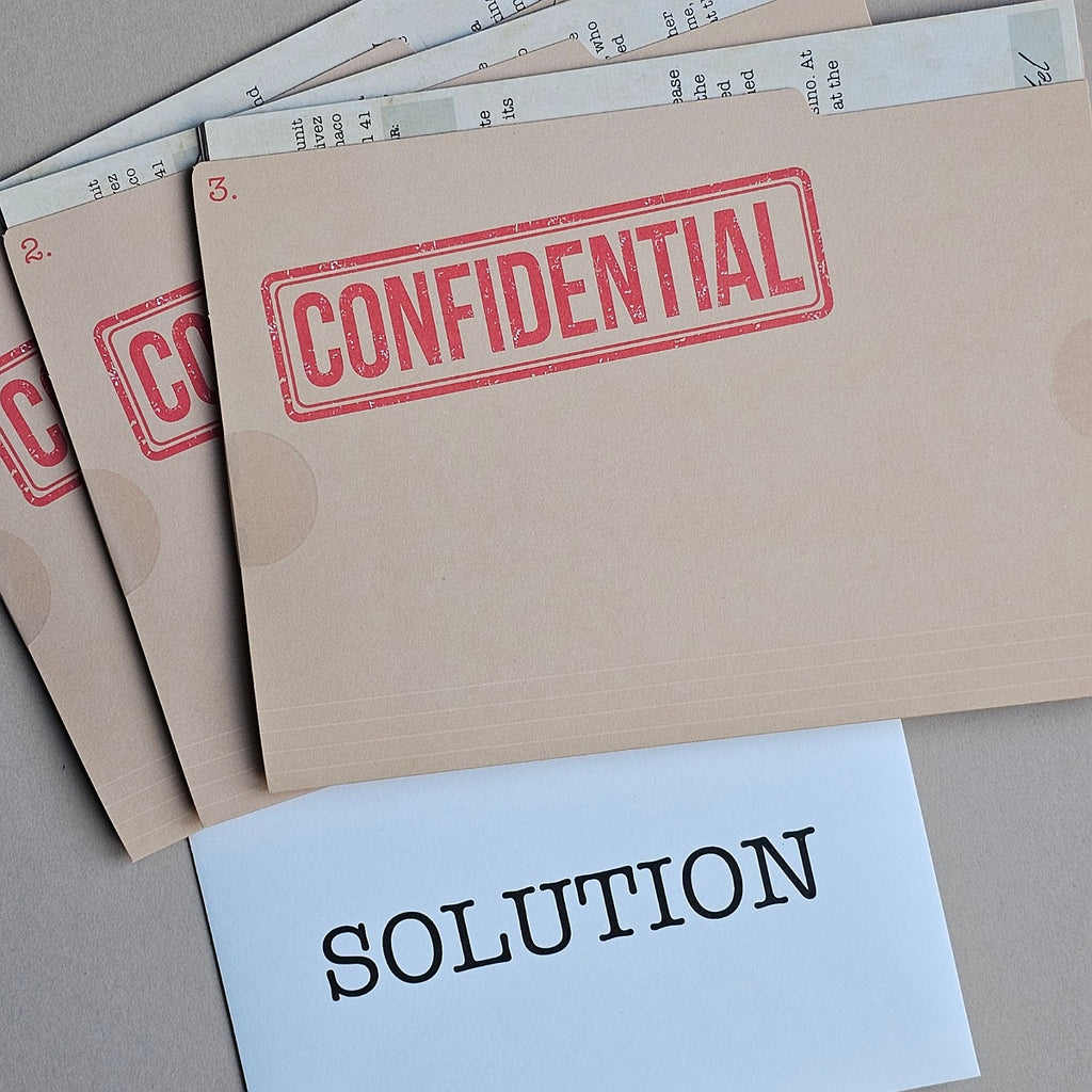 A stack of beige confidential folders stamped with 'CONFIDENTIAL' in red, with a white card labeled 'SOLUTION' in black text in front, on a neutral grey surface.