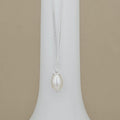 A silver chain necklace with a single teardrop-shaped white pearl pendant, displayed on a white jewelry bust against a beige background.