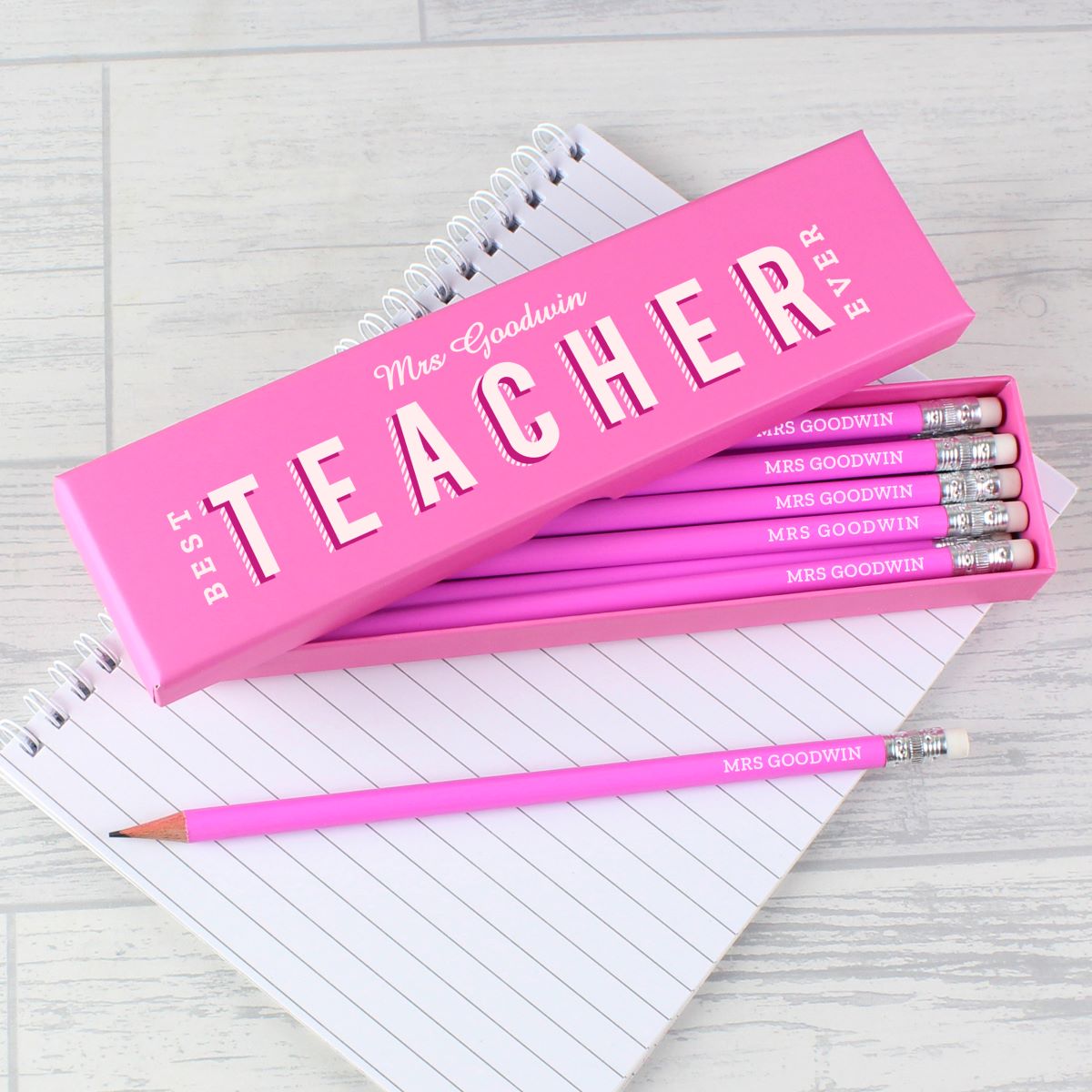 Pink pencil set with 'Best Teacher Ever' text on a notebook