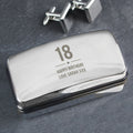 Silver box with '18 Happy Birthday Love Sarah XXX' engraving on a dark surface