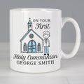 White mug with a design of a church and a boy, and text 'On Your First Holy Communion George Smith' on a gray background.