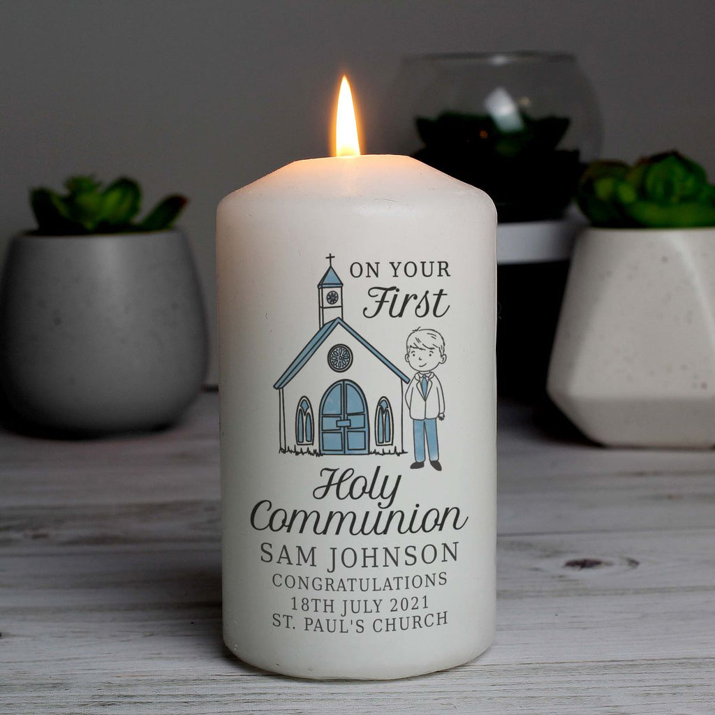 Personalized candle with a church illustration and text on a wooden surface with plants in the background