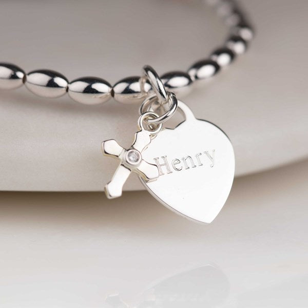 Silver bracelet with a heart-shaped tag engraved with 'Henry' on a light background