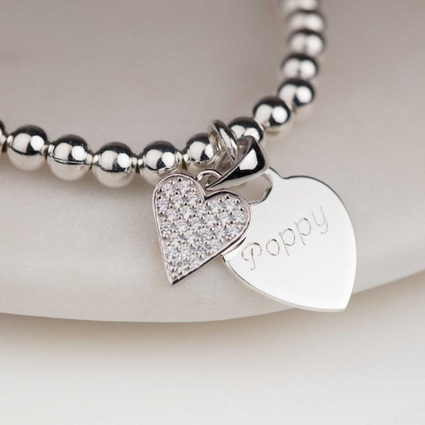 Silver bracelet with heart-shaped charms on a white background