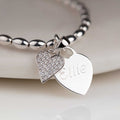 Silver bracelet with heart-shaped charms on a white background