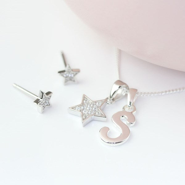 Silver star-shaped pendant and earrings on a white background