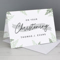 Greeting card with 'On Your Christening' text and leaf patterns on a gray background