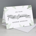Greeting card with 'On Your First Communion' text and green leaf patterns on a gray background