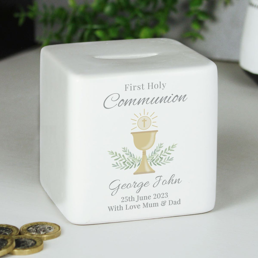 White ceramic money box with First Holy Communion design and engraved text on a light surface.