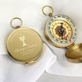 Gold compass with engraved text on a white background