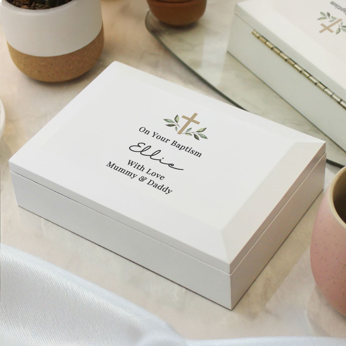 Personalized white box with engraved text on a light wooden surface