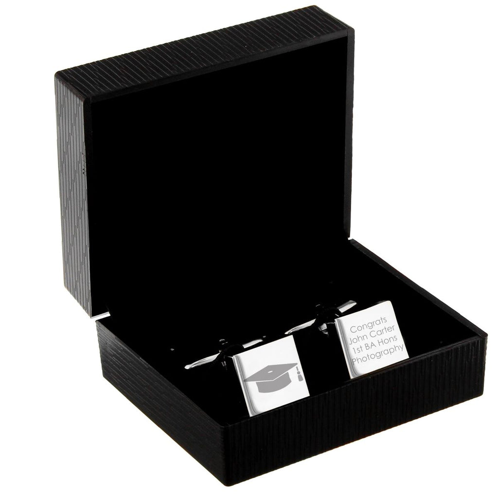A black ribbed presentation box with its lid open, displaying a silver-toned wedding cufflink and matching rectangular tag engraved with a graduation cap icon and the text 'Congrats John Carter 1st BA Honor Photography'.