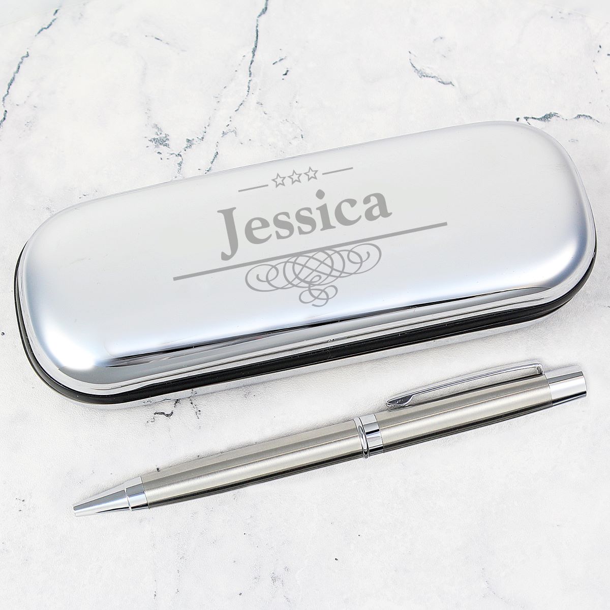 Silver pen and case with 'Jessica' engraving on a marble surface