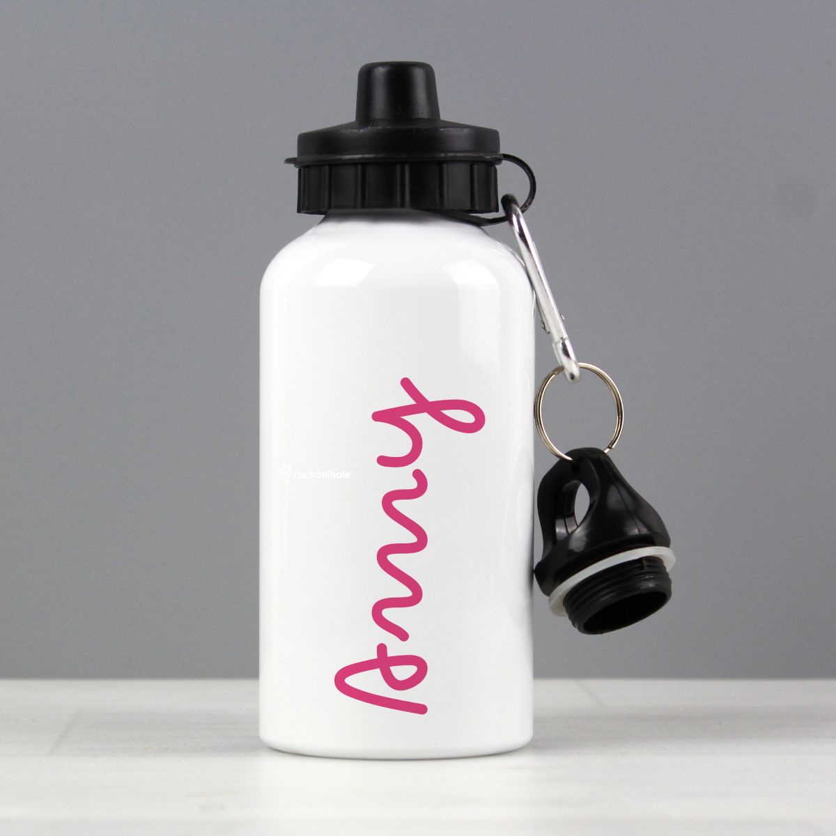 White water bottle with black cap and pink text on a gray background