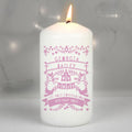 A white pillar candle with a lit flame, featuring pink personalized text and decorative illustrations on the front. The text reads 'GEORGIA BAILEY ON YOUR 1st HOLY COMMUNION 4TH MAY 2022'.