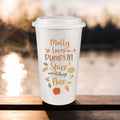A white reusable coffee cup with a lid sits on a wooden railing outdoors. The cup has a printed autumn-themed quote reading “Molly loves Pumpkin Spice and all things Nice” in orange and brown lettering, with small pumpkins, leaves, and fall motifs.