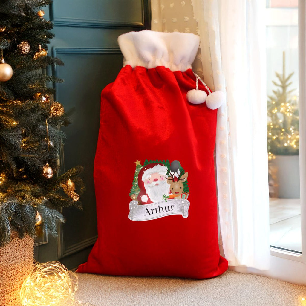 Red Christmas sack with Santa Claus design and 'Arthur' text next to a decorated Christmas tree.