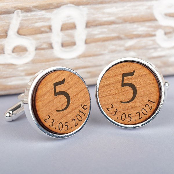 A pair of round silver cufflinks with engraved light brown wood faces, featuring the number 5 and personalised date '23.05.2021'.