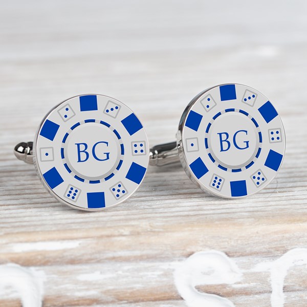 A pair of round silver-toned cufflinks styled like blue and white casino chips. Each one has a white center blue border segments, and the initials 'BG' in blue.