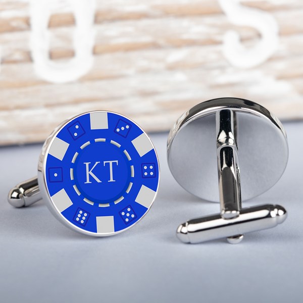 A pair of round silver-toned cufflinks styled like blue and white casino chips. One cufflink is shown from the front with a blue center, white border segments, and the initials 'KT' in white.