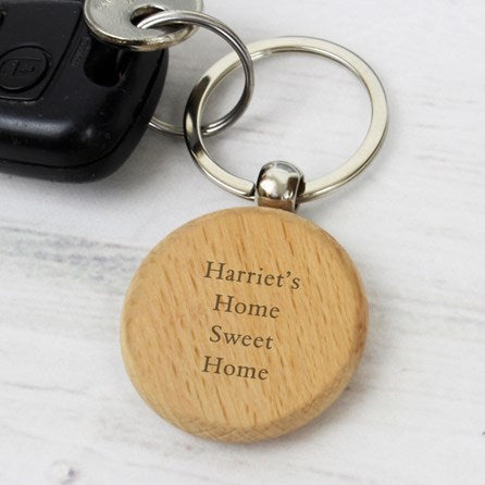 Wooden keychain with 'Harriet's Home Sweet Home' engraving on a white background