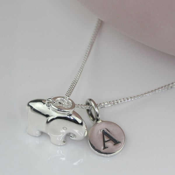 Silver necklace with elephant pendant and letter 'A' charm on a white background