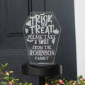 Halloween-themed acrylic sign with 'Trick or Treat' message on a black background