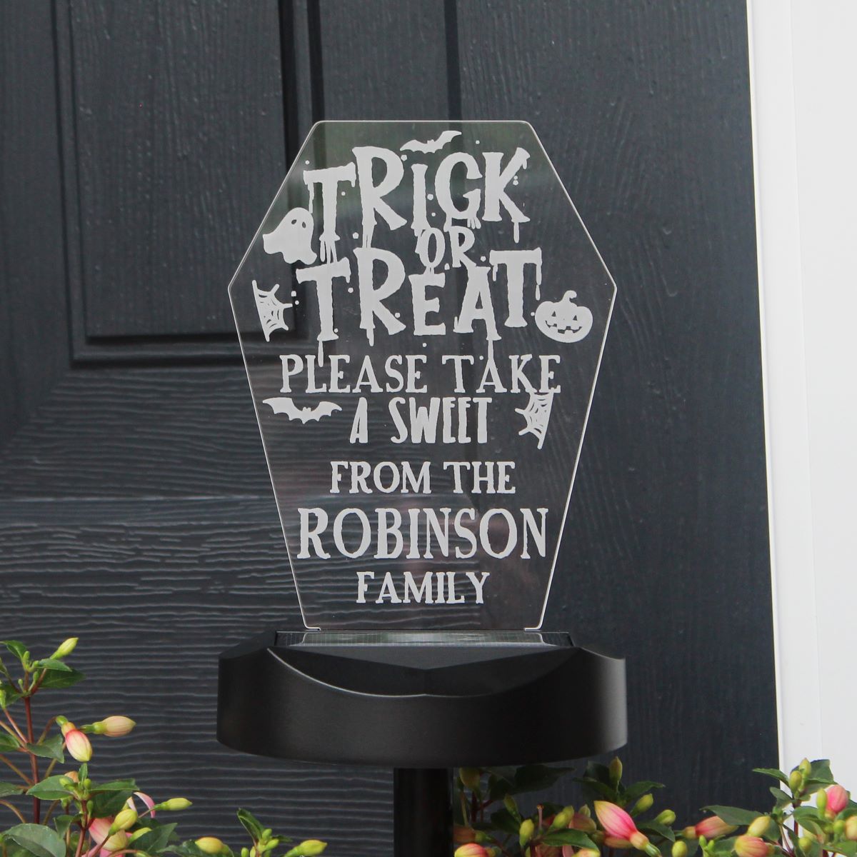 Halloween-themed acrylic sign with 'Trick or Treat' message on a black background