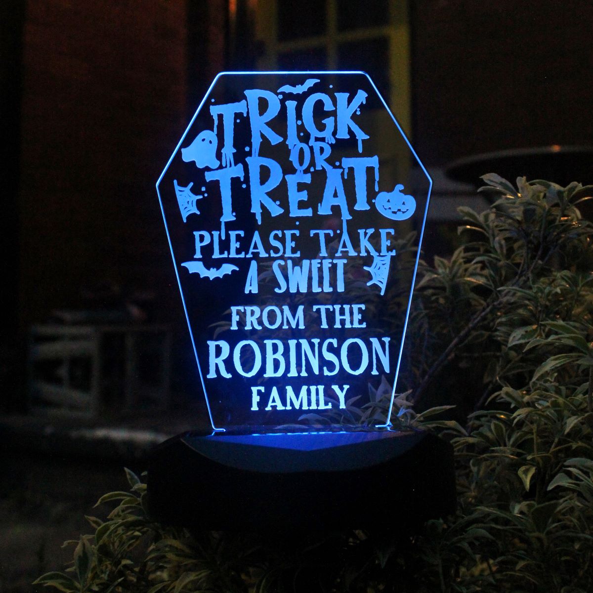 Decorative LED sign with Halloween text and family name on a dark background