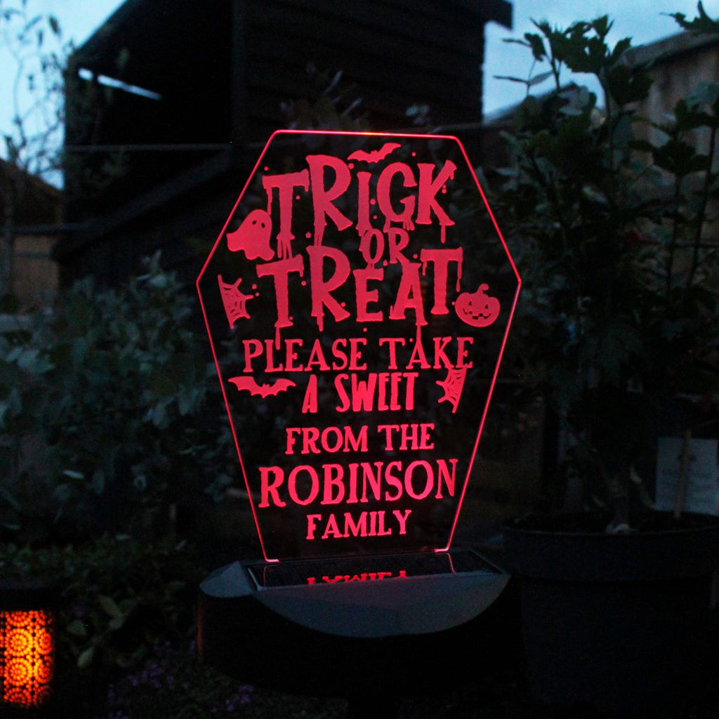 Halloween-themed LED sign with personalized text in a dark outdoor setting.