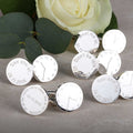 Silver cufflinks with various engraved text on a grey surface with greenery in the background, each set of cufflinks has a time on one and wording on the other including 'See you later', Don't be late', You and me'.