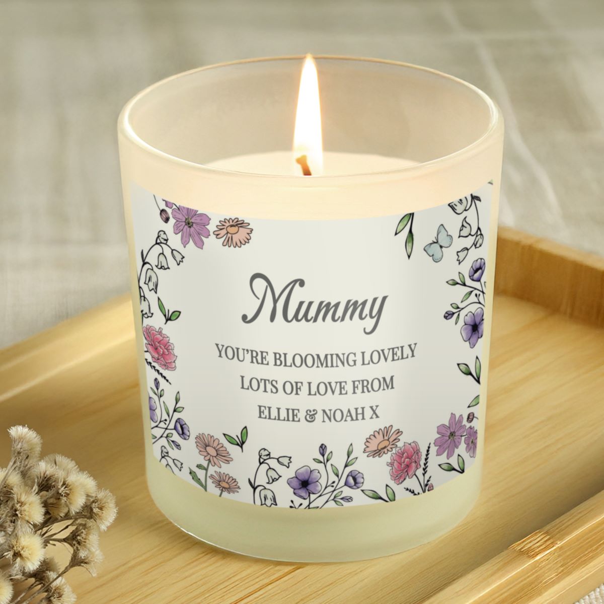 Candle with a decorative label on a wooden surface