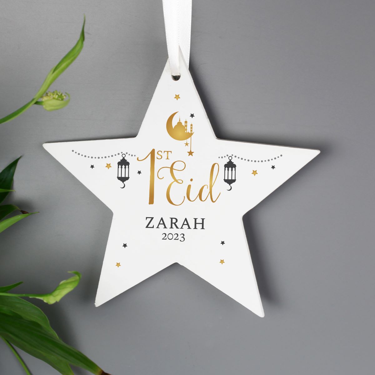 White star-shaped ornament with '1st Eid Zarah 2025' text on a gray background