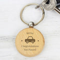 Wooden keychain with engraved text and car illustration on a white background