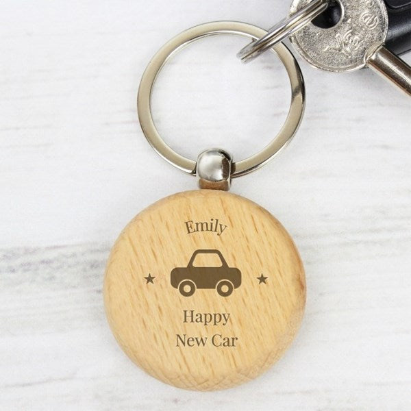Wooden keychain with engraved text and car symbol on a white background
