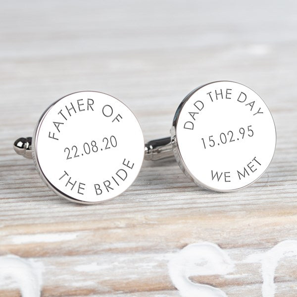 A pair of round silver cufflinks engraved with personalised wedding text, including 'FATHER OF THE BRIDE' and 'DAD THE DAY WE MET' both with a different engraved date.