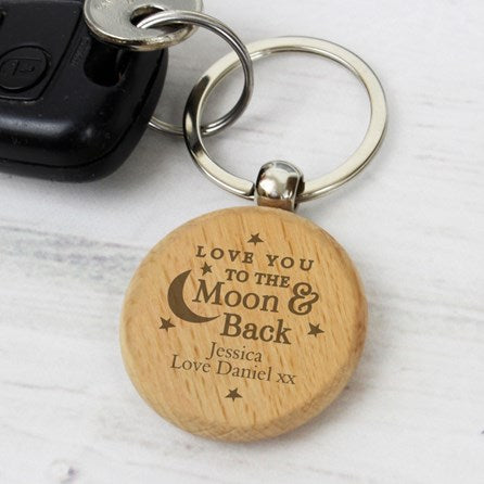 Wooden keychain with engraved message on a light surface