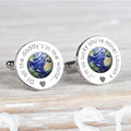 A pair of round silver cufflinks featuring a detailed globe of Earth in the centre, surrounded by engraved personalised text 'Of all the daddy's in the world..' on one and '...I'm so lucky you're mine!  Lauren x' on the other and a small heart, displayed on a neutral grey surface.
