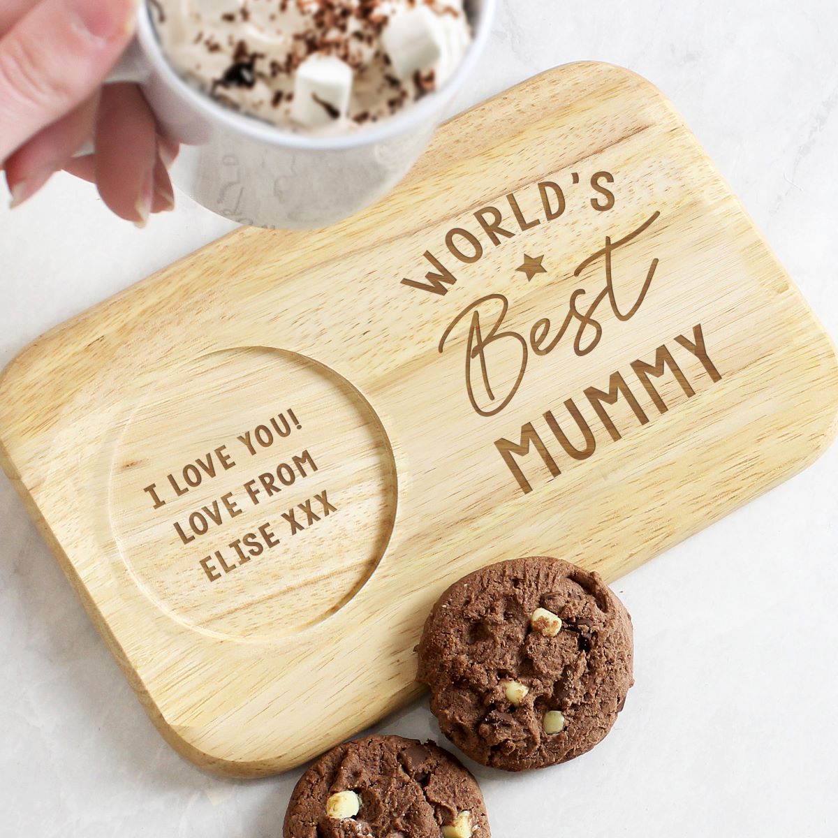 Wooden coaster with 'World's Best Mummy' and 'I love you, love from Elise' text, next to cookies and a mug.