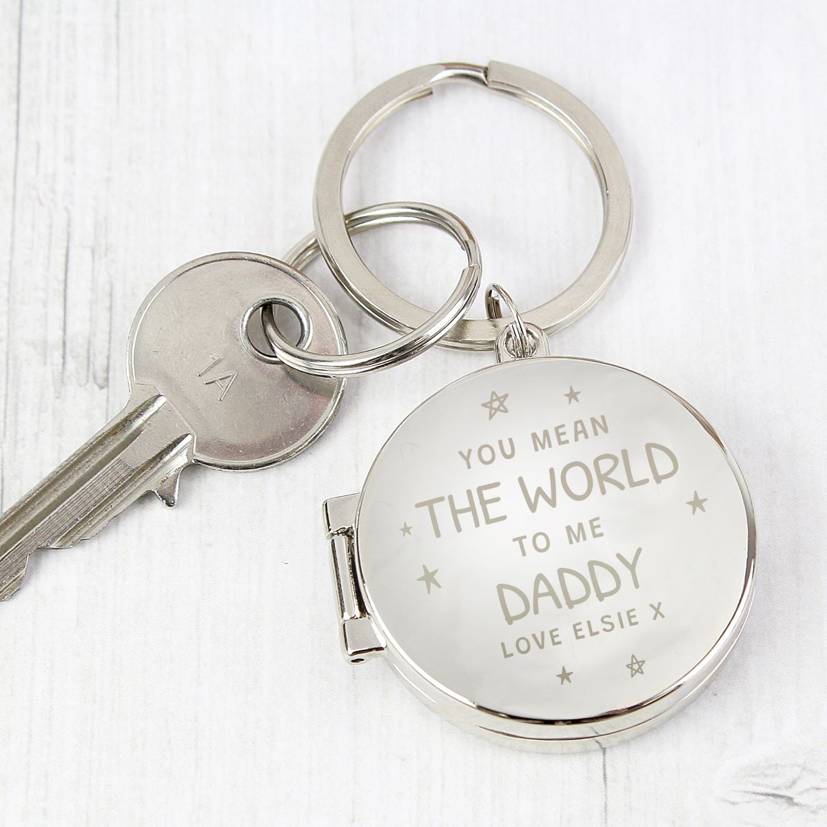 Silver keychain with engraved message on a white background