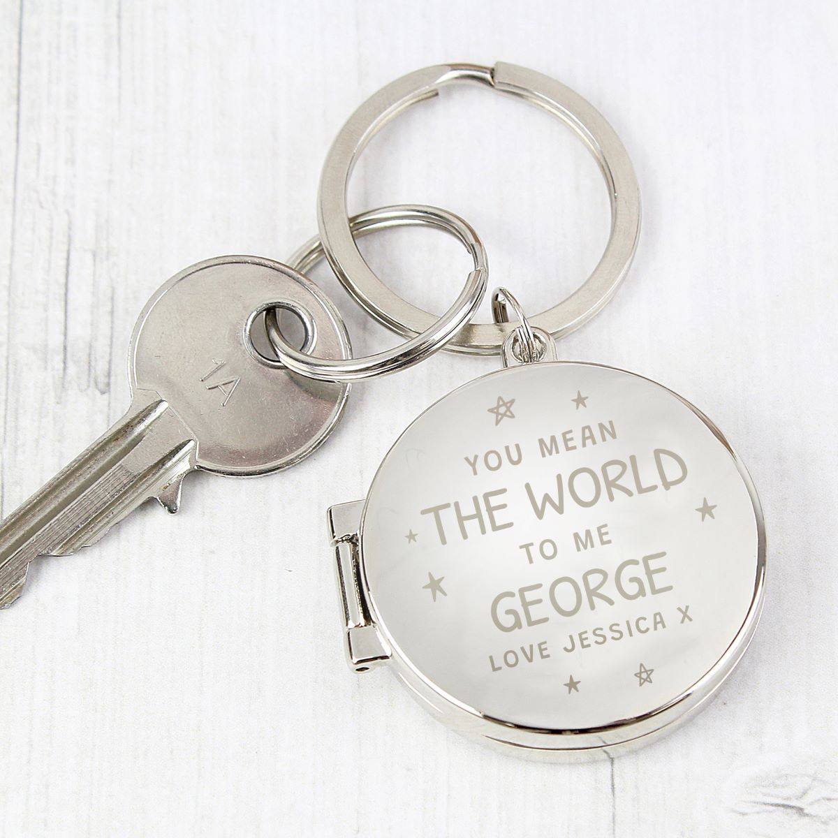 Silver keychain with engraved message on a white background