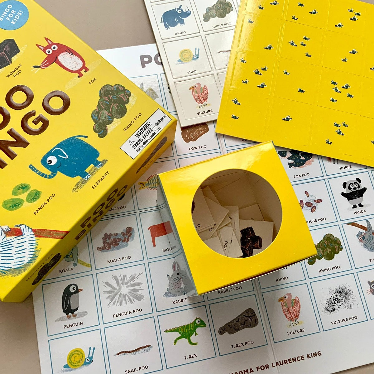 Yellow children's board game with illustrations of animals and a box on top, surrounded by game cards.