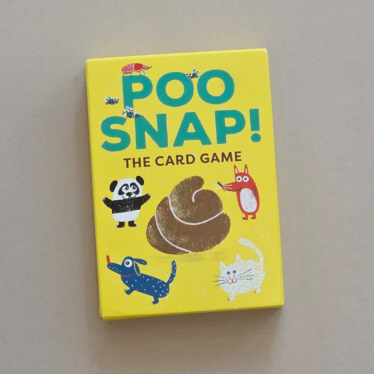 Yellow card game box titled 'Poo Snap!' with cartoon illustrations on a beige background
