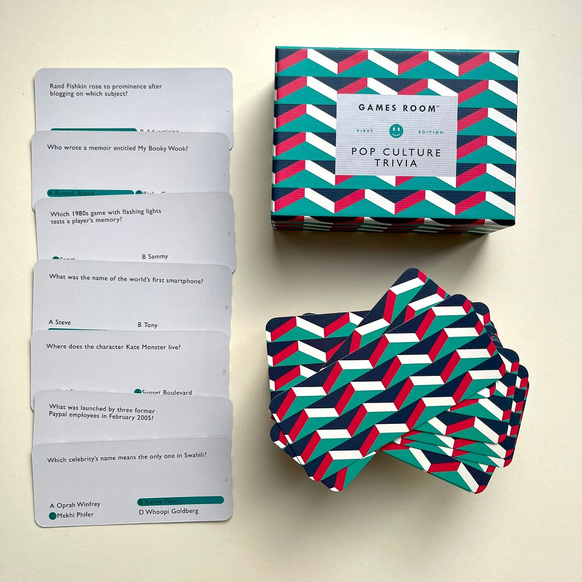 Games Room 'Pop Culture Trivia' card game set with a patterned box, a stack of cards, and individual cards displayed on a light beige background.