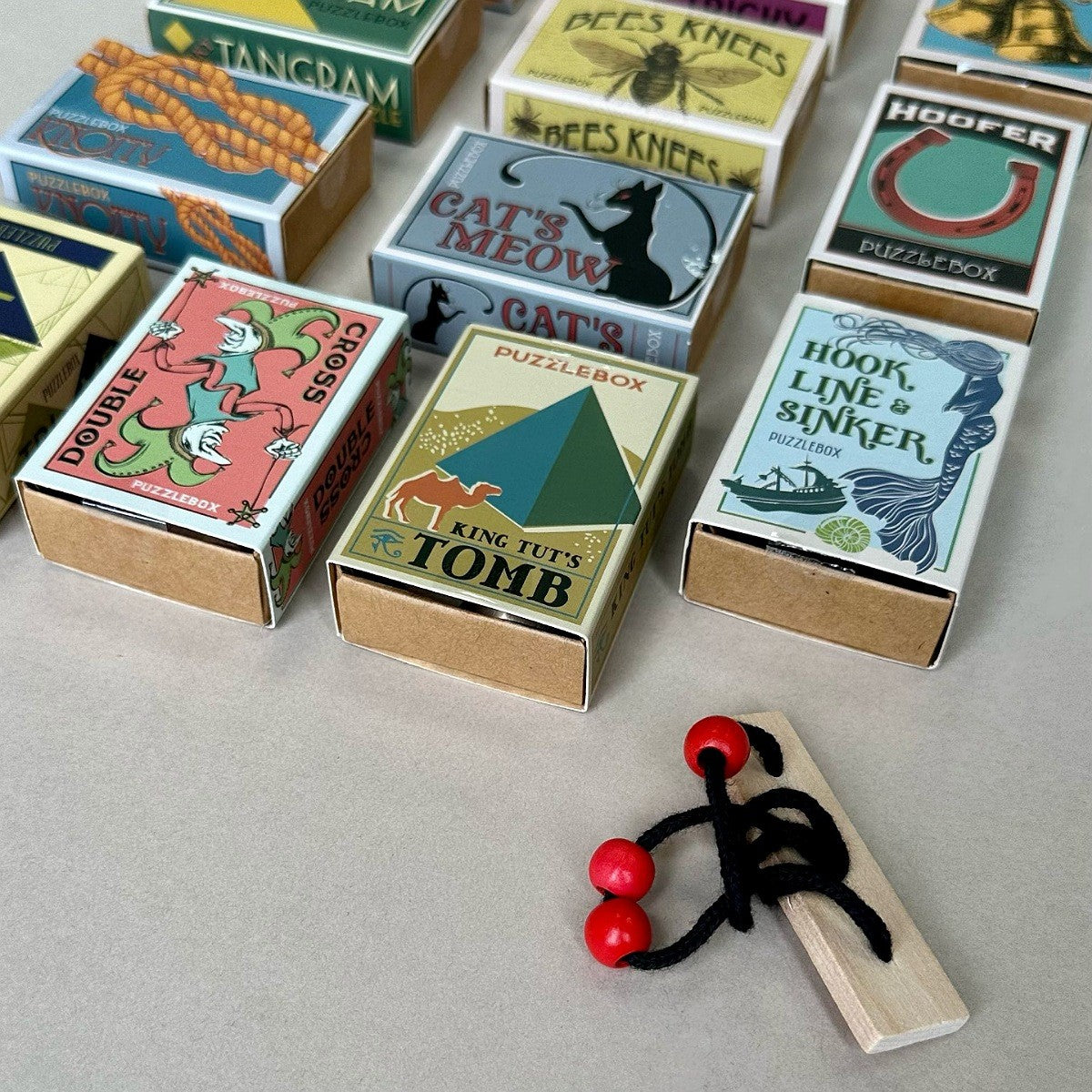 Collection of vintage-style matchboxes with colorful labels on a light grey surface.