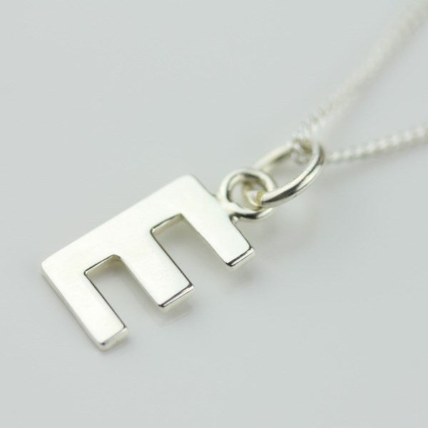 Silver necklace with a letter 'E' pendant on a light gray background