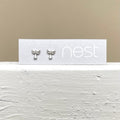 A silver pair of angel earrings on a backing card