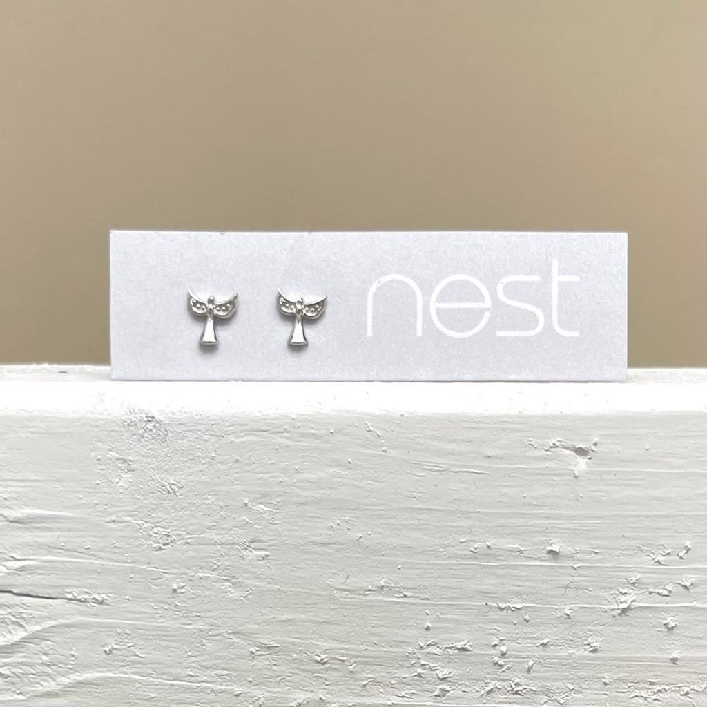 A silver pair of angel earrings on a backing card