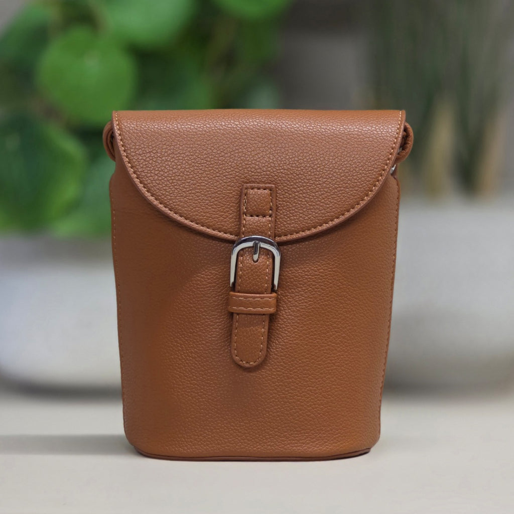 Brown leather pouch with a buckle on a blurred background